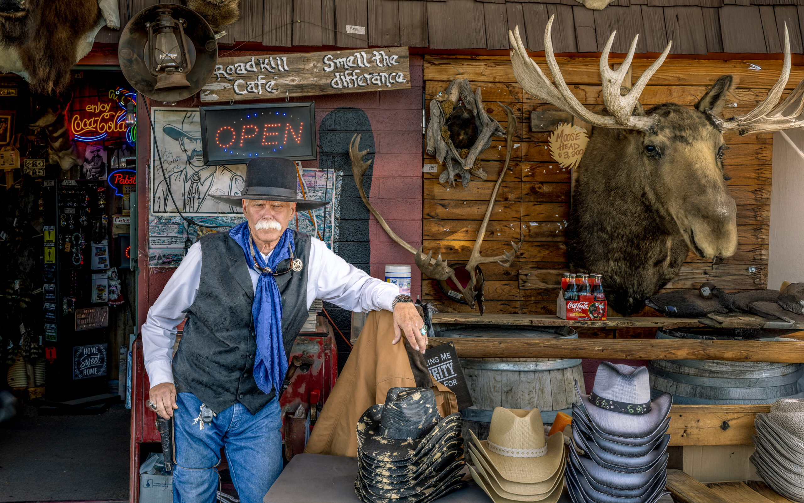 Cowboyfiguur naast een elandkop aan de muur in een souvenirwinkel langs Route 66.